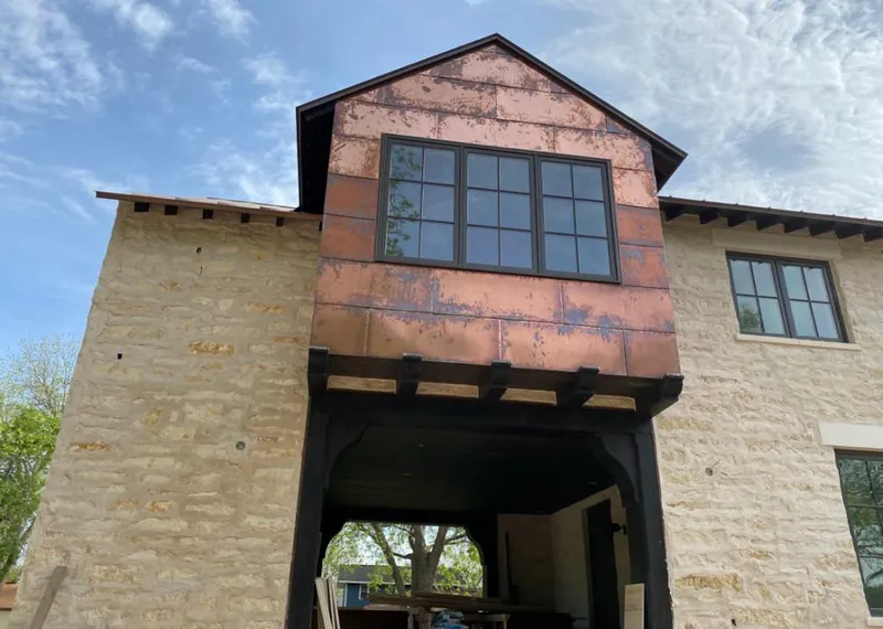 Copper metal panel facade on a stone building for Skylight Installation in Ada